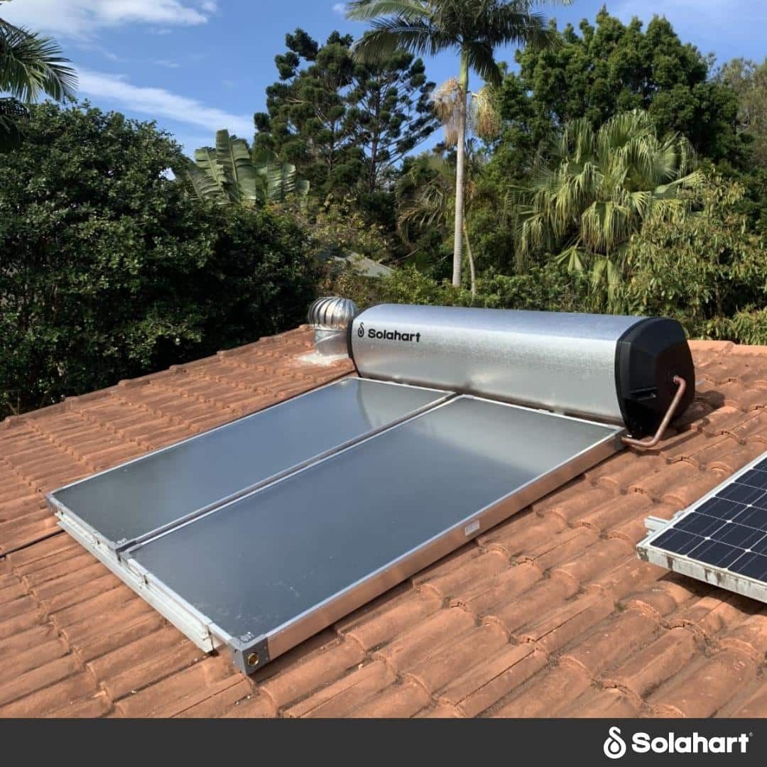 A Solar Water Heater Is Sitting On Top Of A Roof Next To A Solar Panel — David Lewis Solahart in Goonellabah, NSW