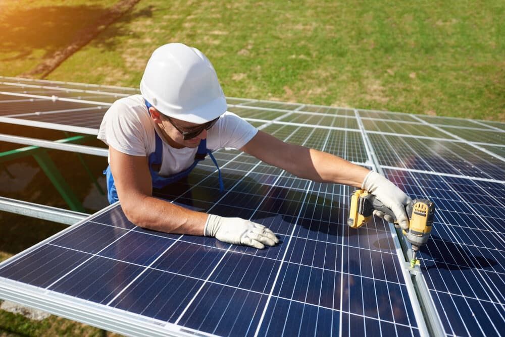 A Man Is Working On A Solar Panel With A Drill — David Lewis Solahart in Bangalow, NSW