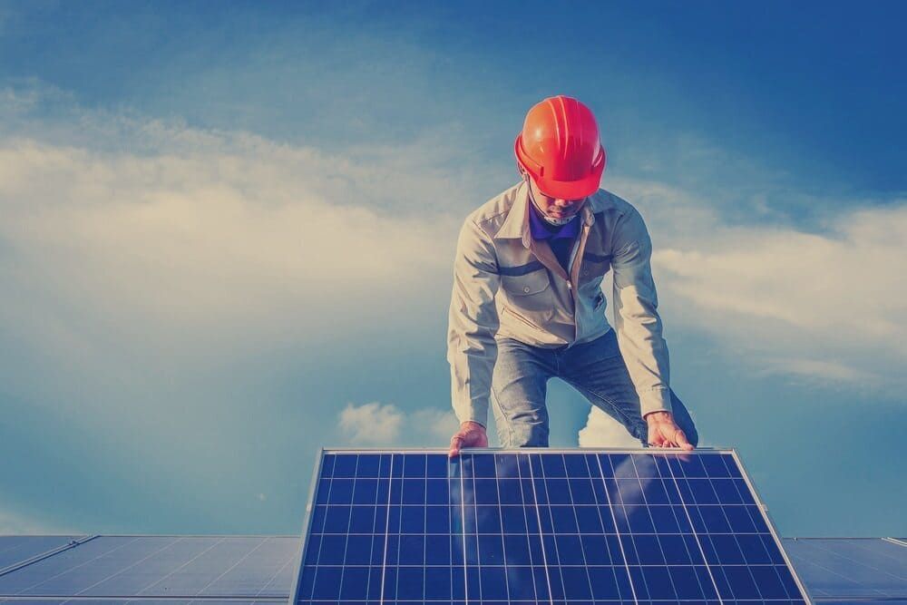 A Man Wearing A Hard Hat Is Standing On Top Of A Solar Panel — David Lewis Solahart in Byron Bay, NSW