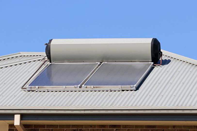 Solar Water Heater Is Mounted On The Roof Of A House — Solahart In Goonellabah, NSW
