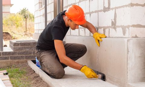 Man Putting Black Paint on Wall Corner — Lancaster, PA — Shelley Basement Systems Man Putting Black Paint on Wall Corner — Lancaster, PA — Shelley Basement Systems