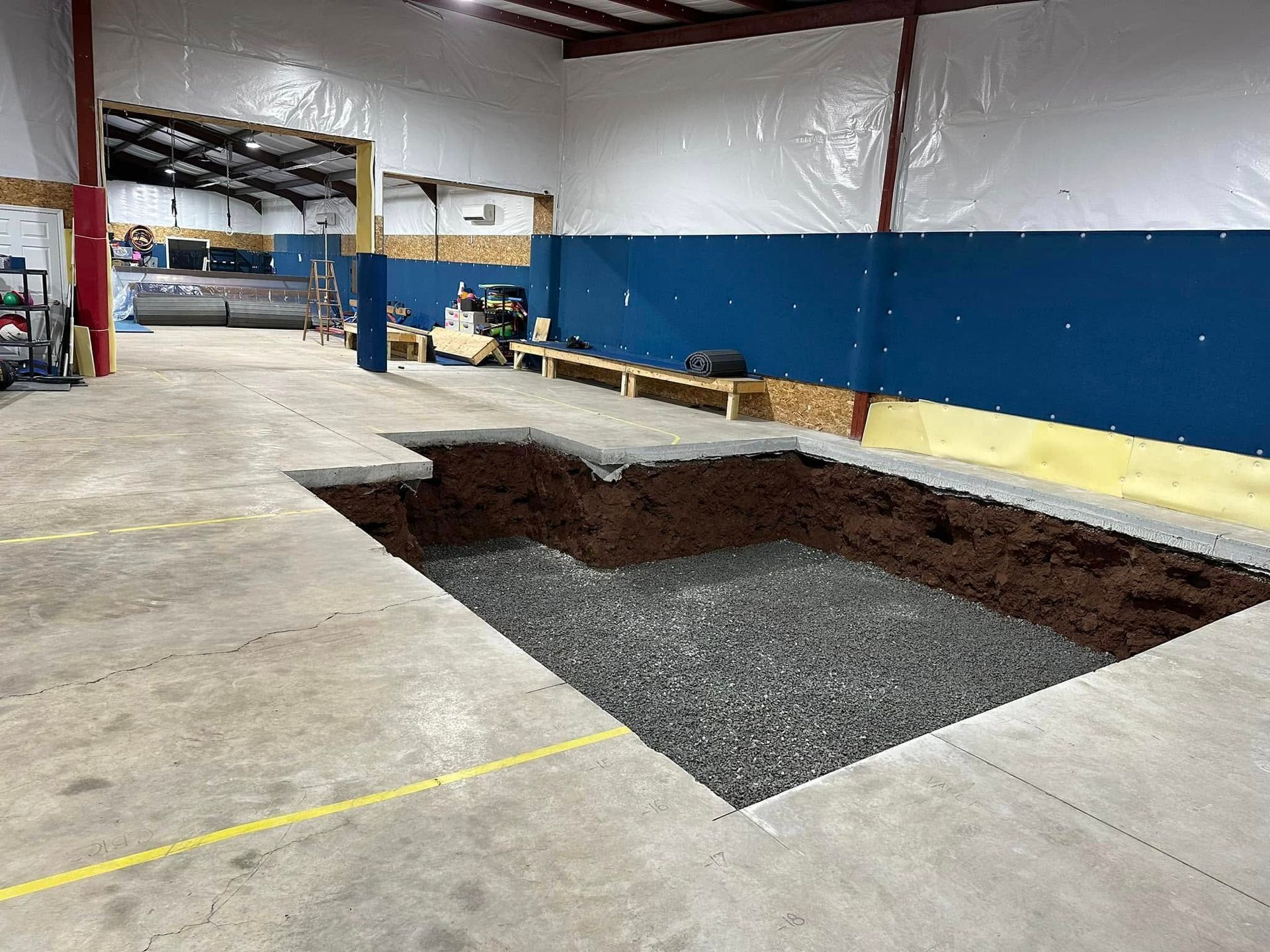 Large interior space with a rectangular pit filled with gravel in the floor.
