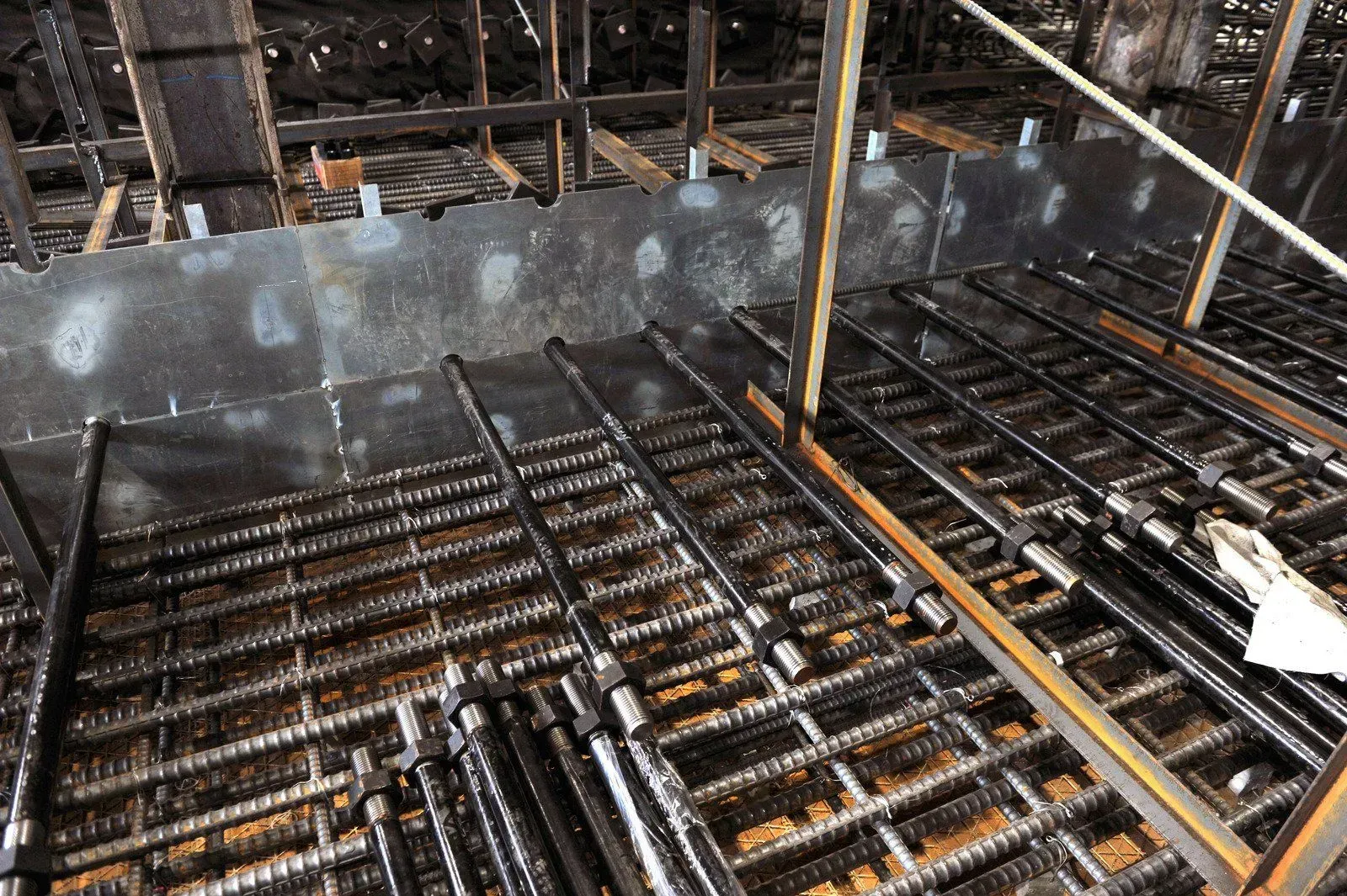 A construction site with a lot of metal bars on the floor.
