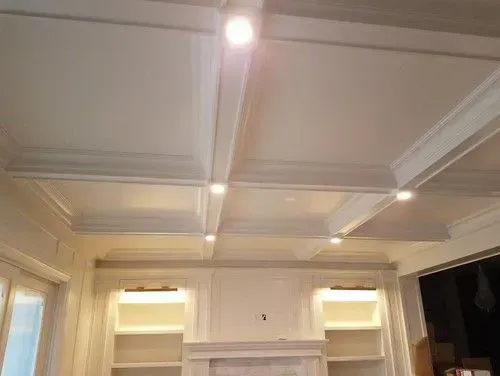 A living room with a fireplace and a coffered ceiling.