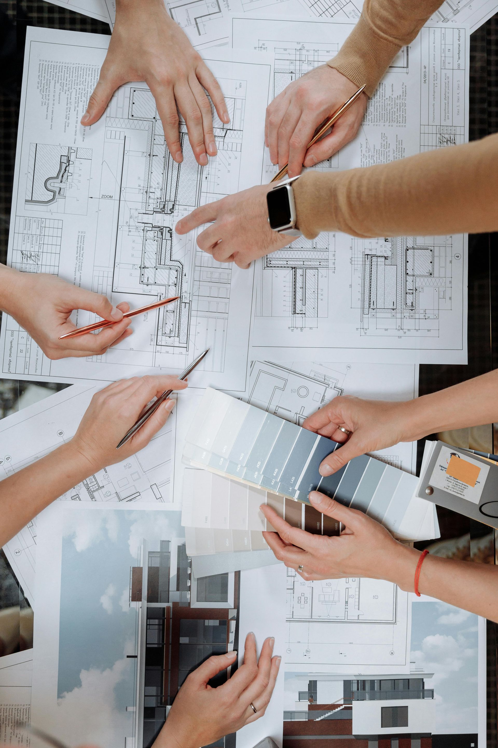 A group of people are sitting around a table working on a project.