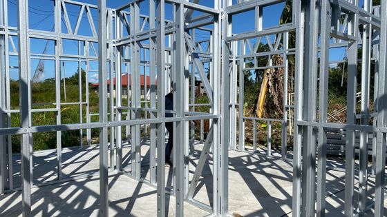 A man is standing in the middle of a building under construction.