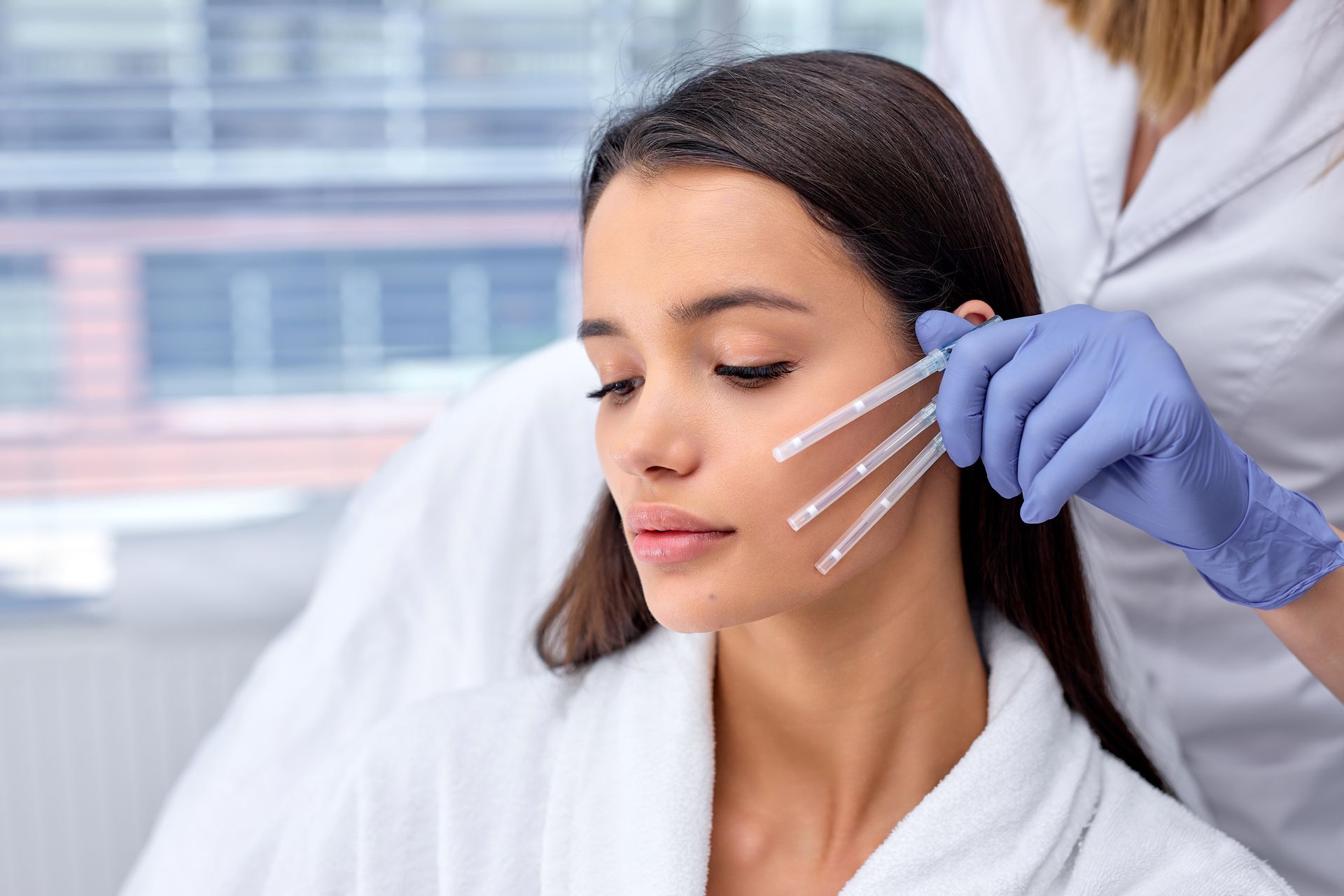 A woman is getting a botox injection in her face.