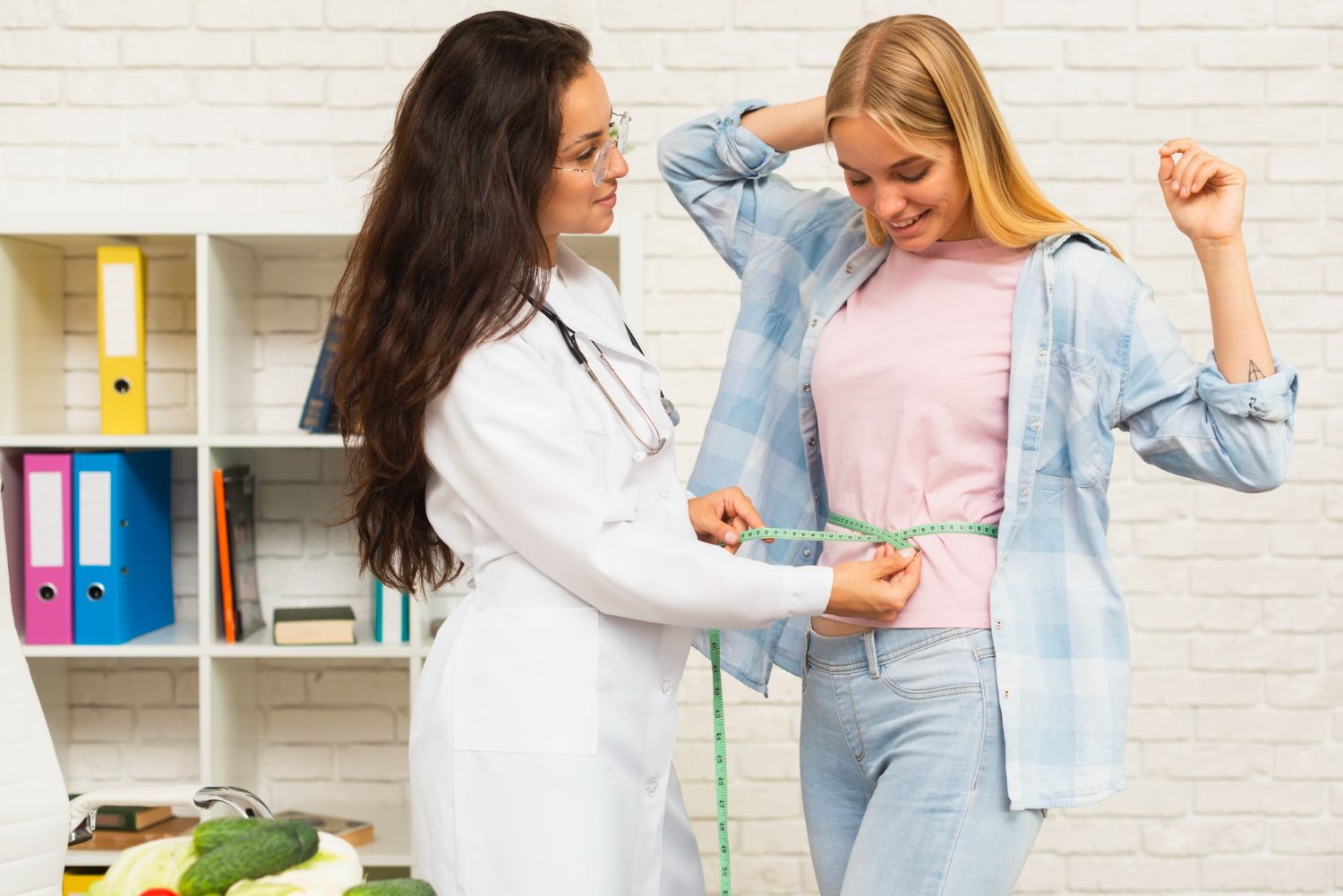 A doctor is measuring a woman 's waist with a tape measure.