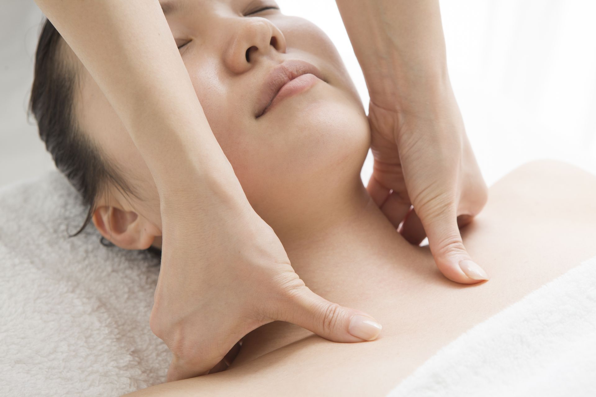 A woman is getting a massage on her neck and chest.