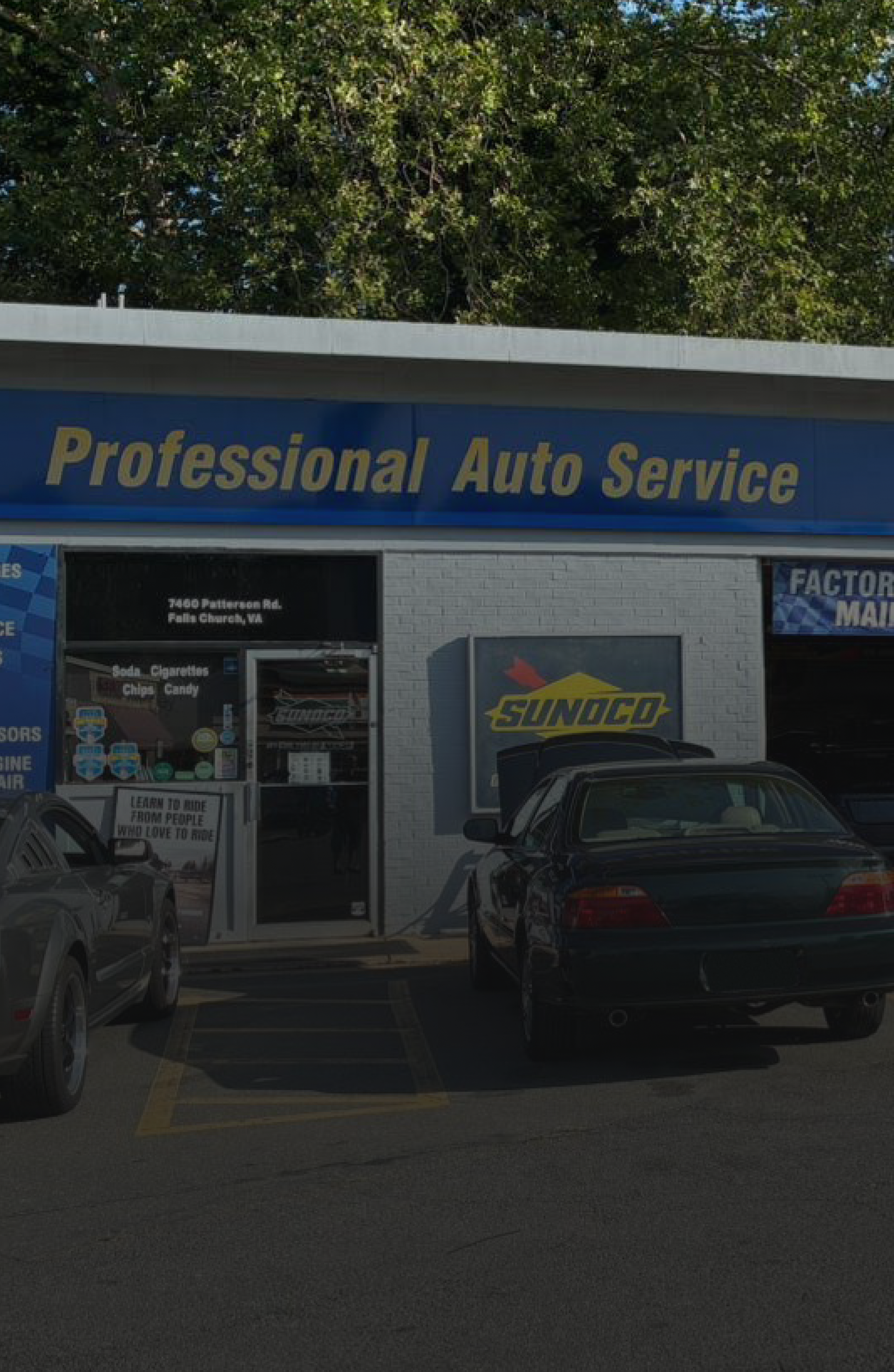 Auto repair shop storefront with blue sign reading “Professional Auto Service” and cars parked outside
