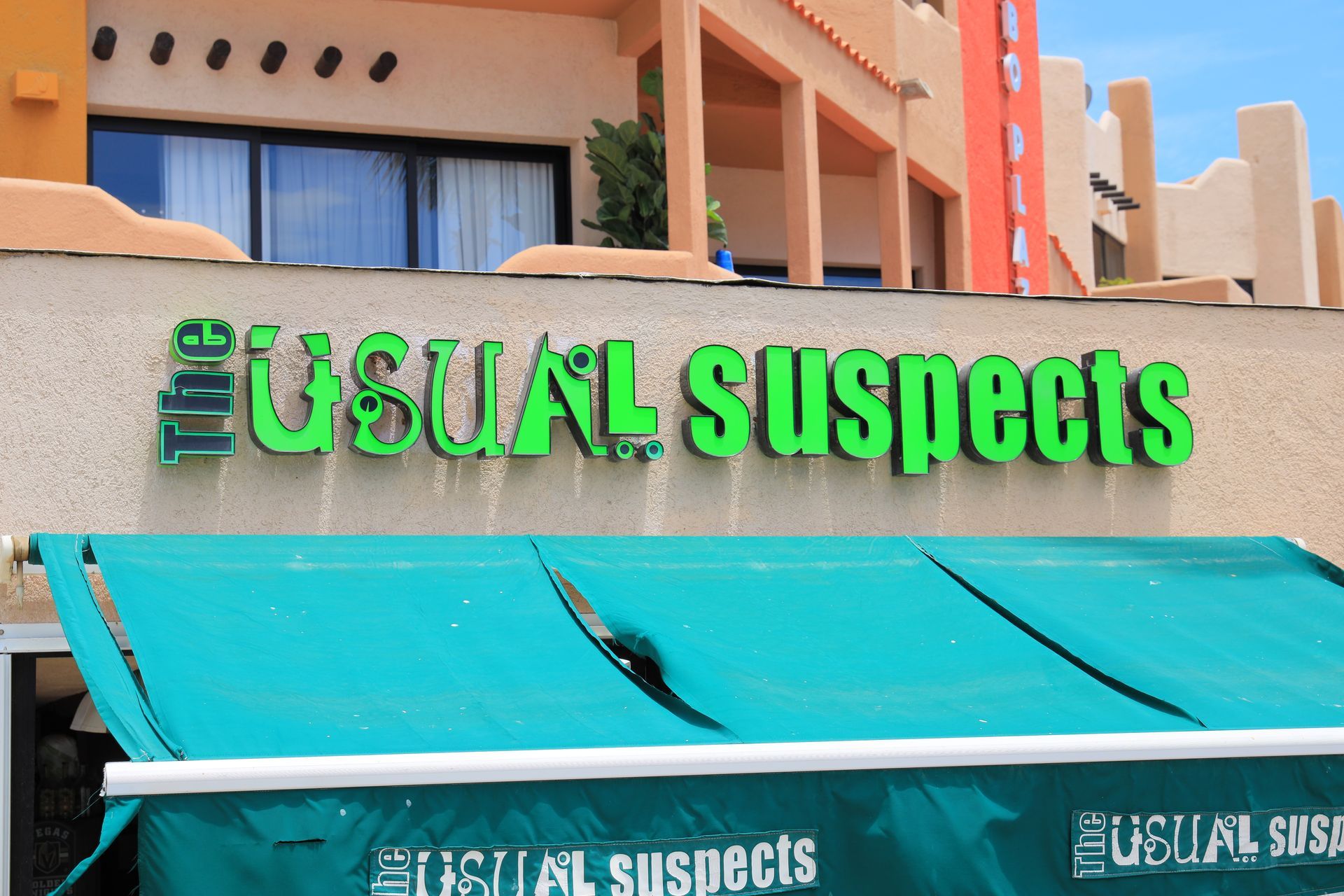 A green sign that says usual suspects on it