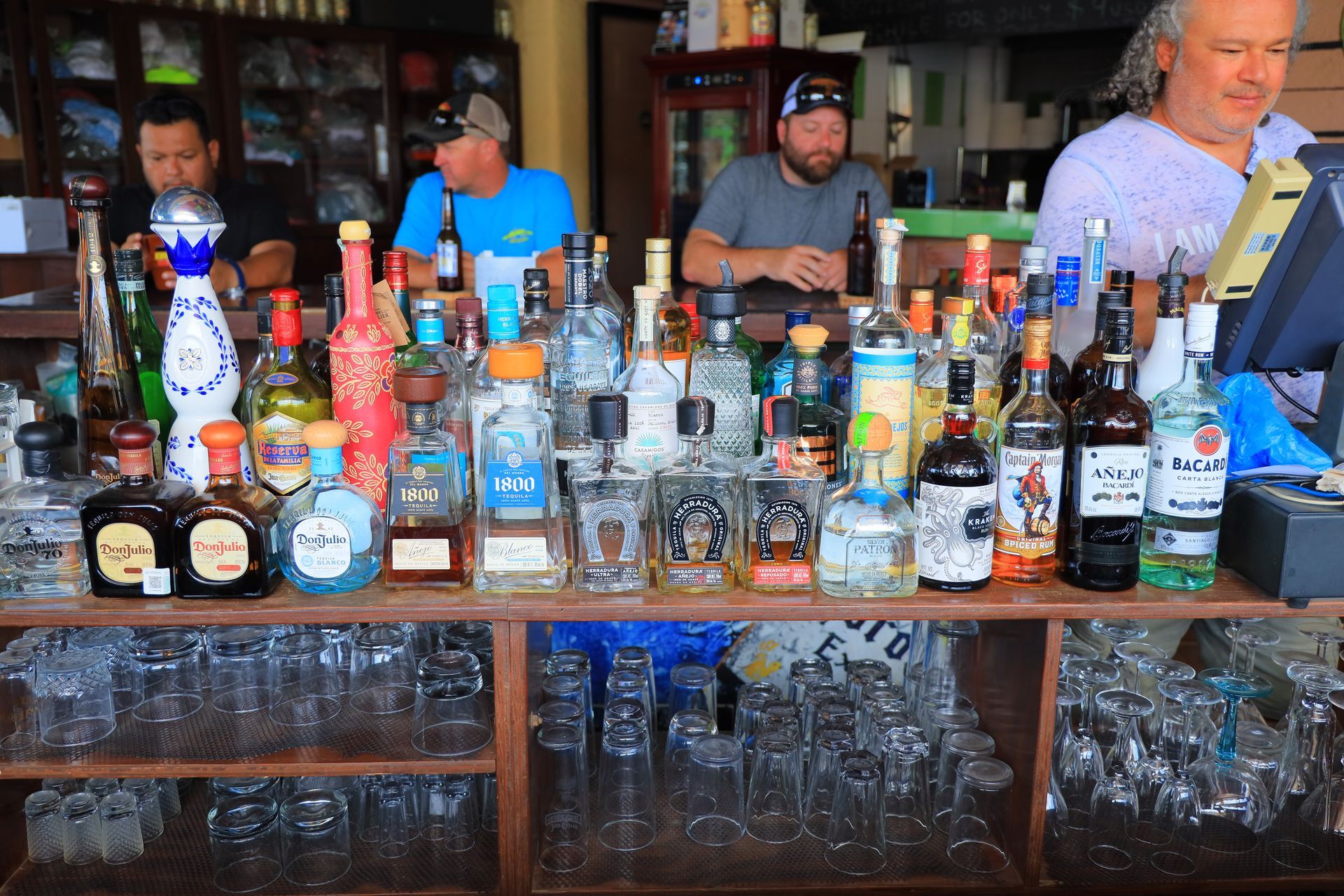 A bar with a lot of bottles and glasses on it