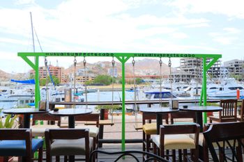 A restaurant with tables and chairs and a green swing