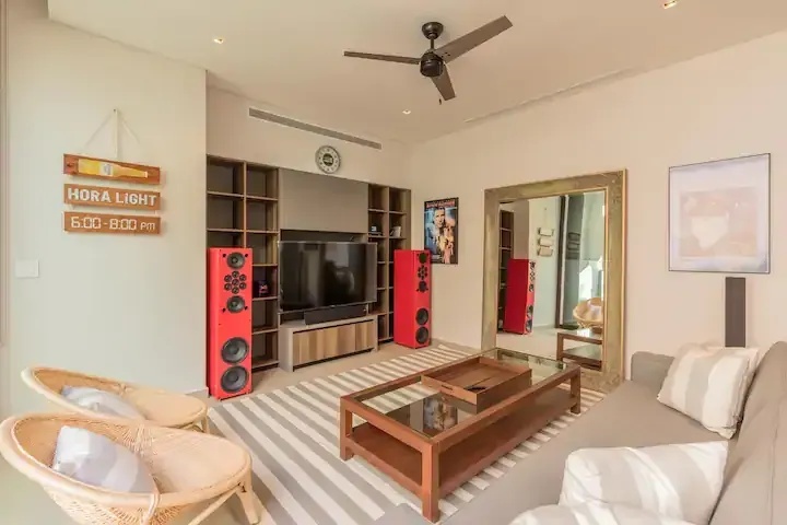 A living room with a couch , chairs , coffee table and television.