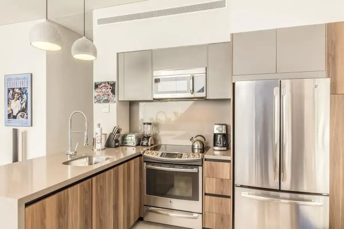 A kitchen with stainless steel appliances and wooden cabinets.