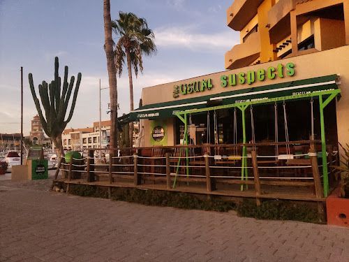 A restaurant with a green awning and a cactus in front of it