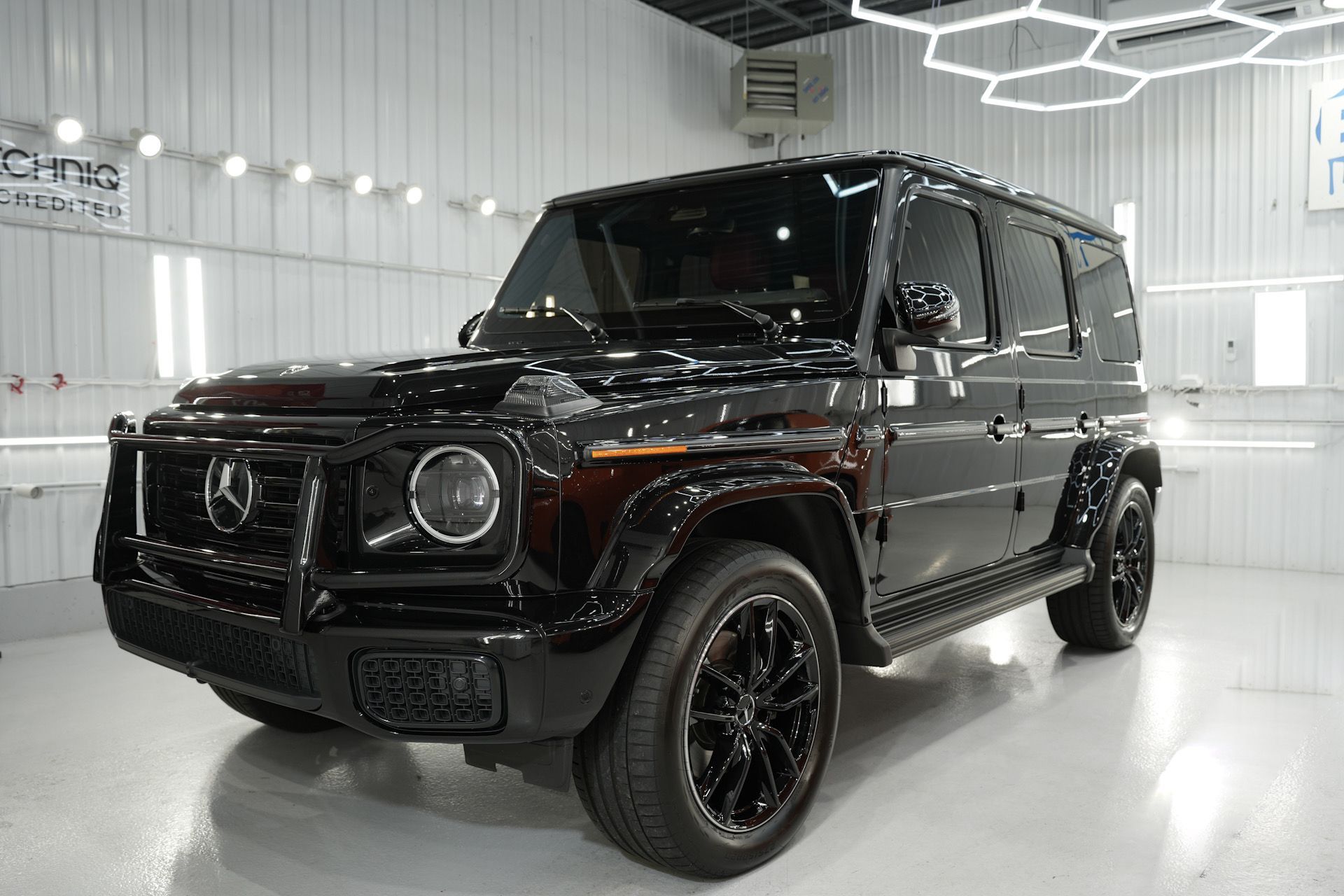 Black Mercedes-Benz G-Wagon parked in a well-lit auto detailing studio.