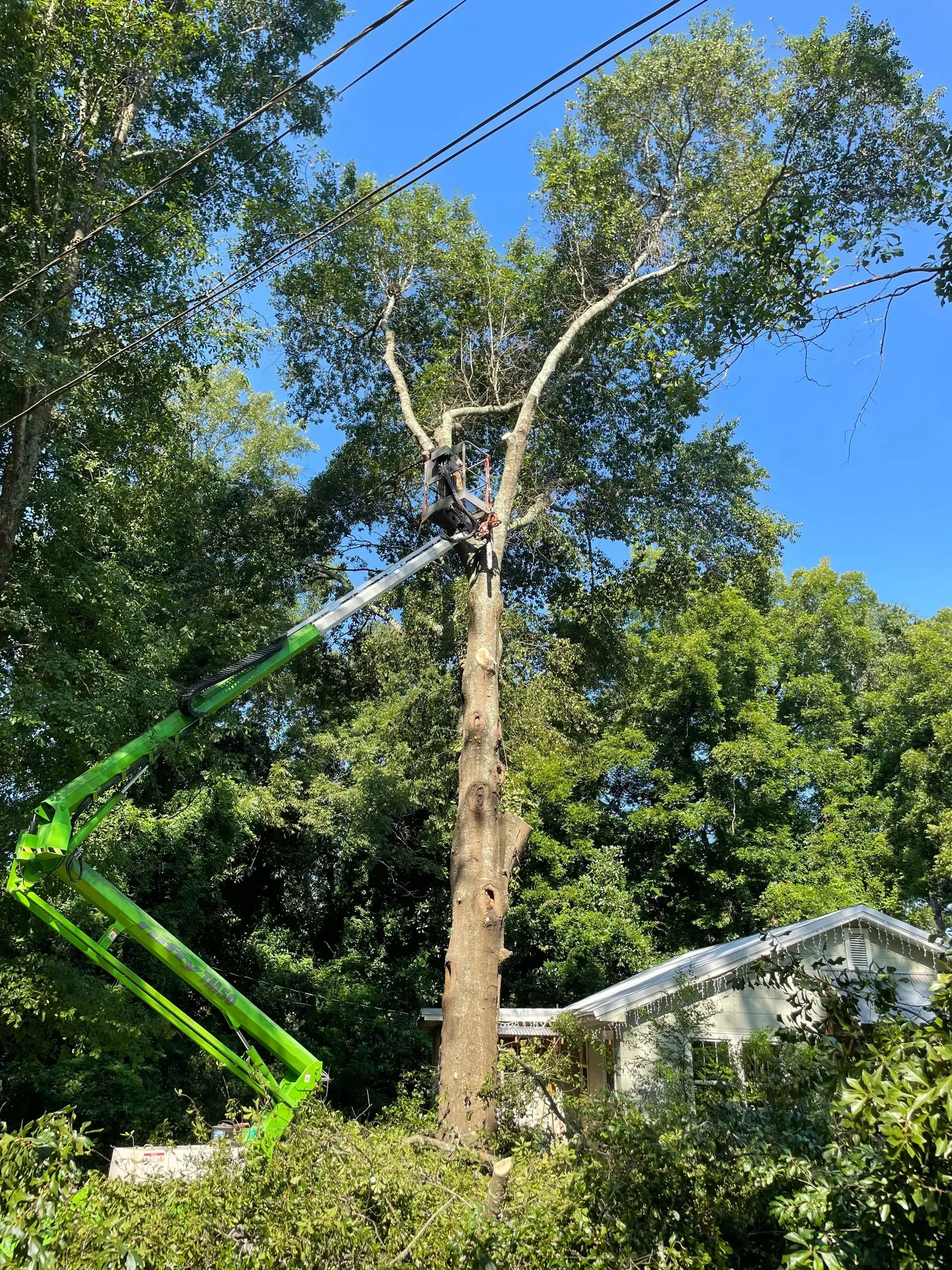 A delivery man in a red shirt is writing on a clipboard