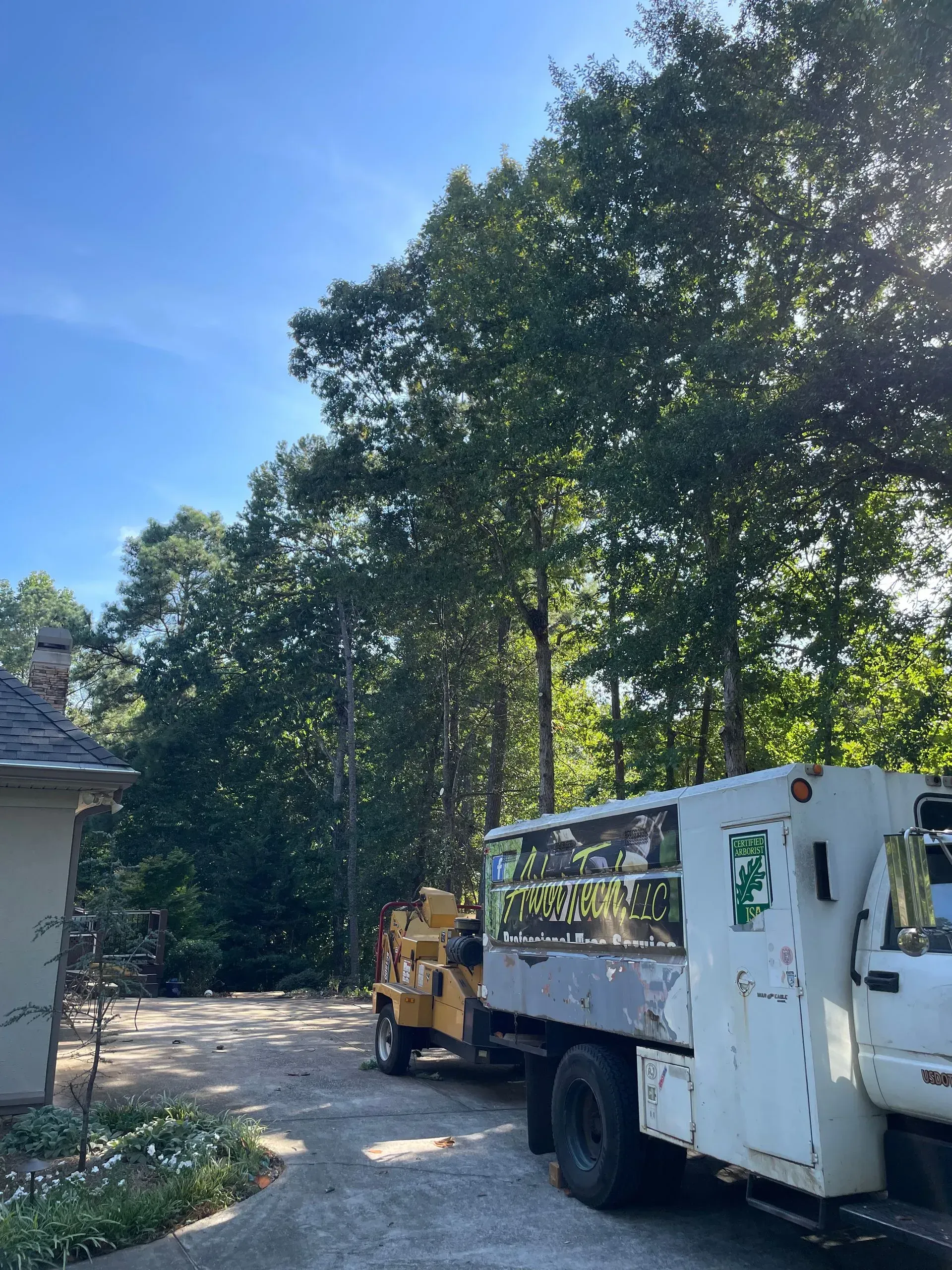 A white truck is parked in a driveway next to a house.
