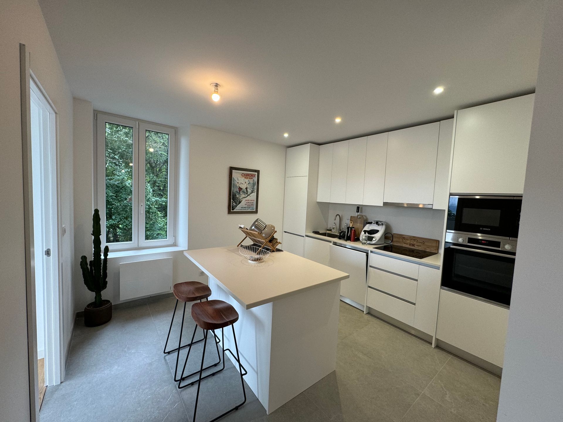 Une cuisine avec des armoires blanches et un grand îlot au milieu