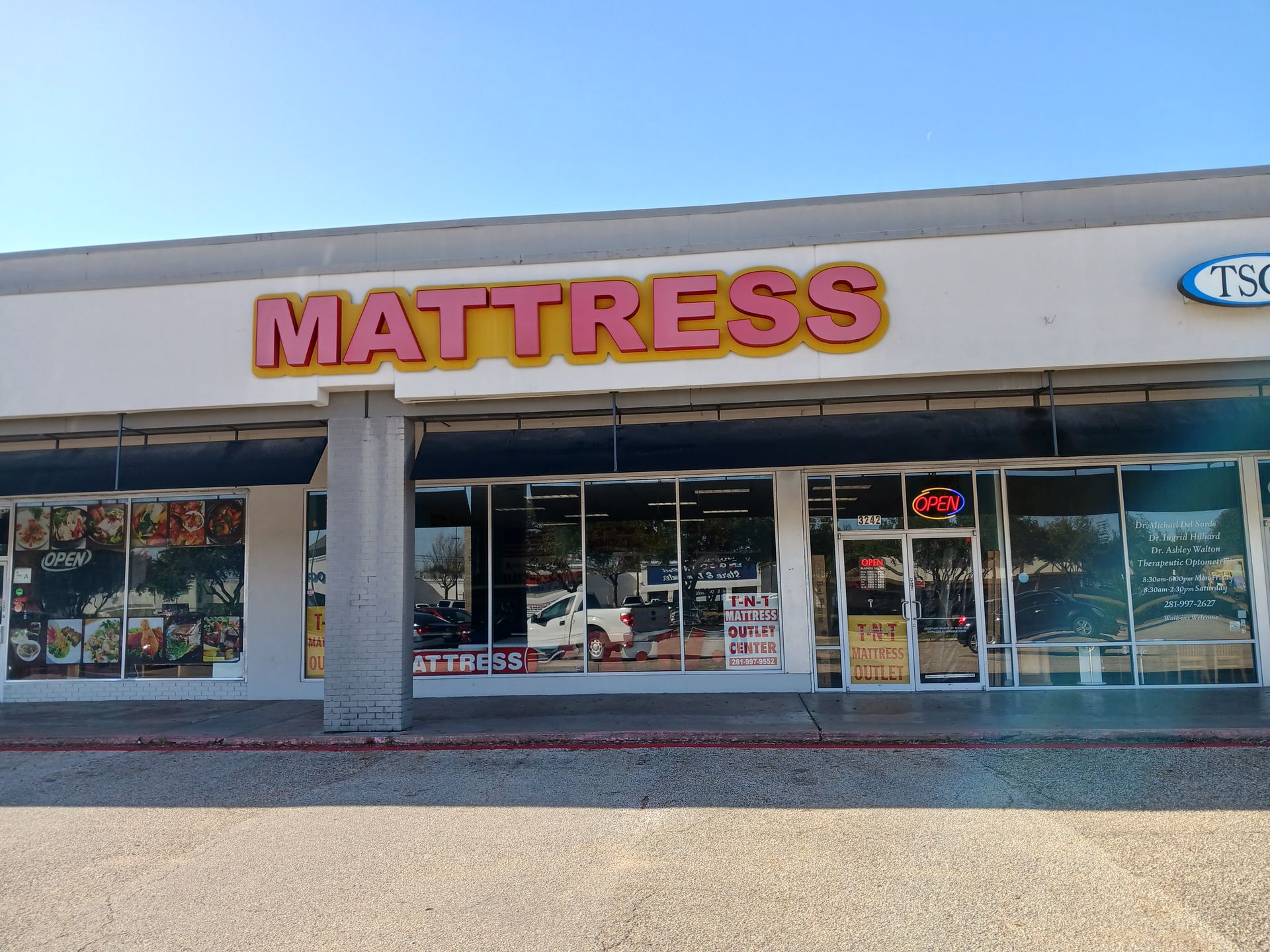 The outside of a mattress store with an open sign