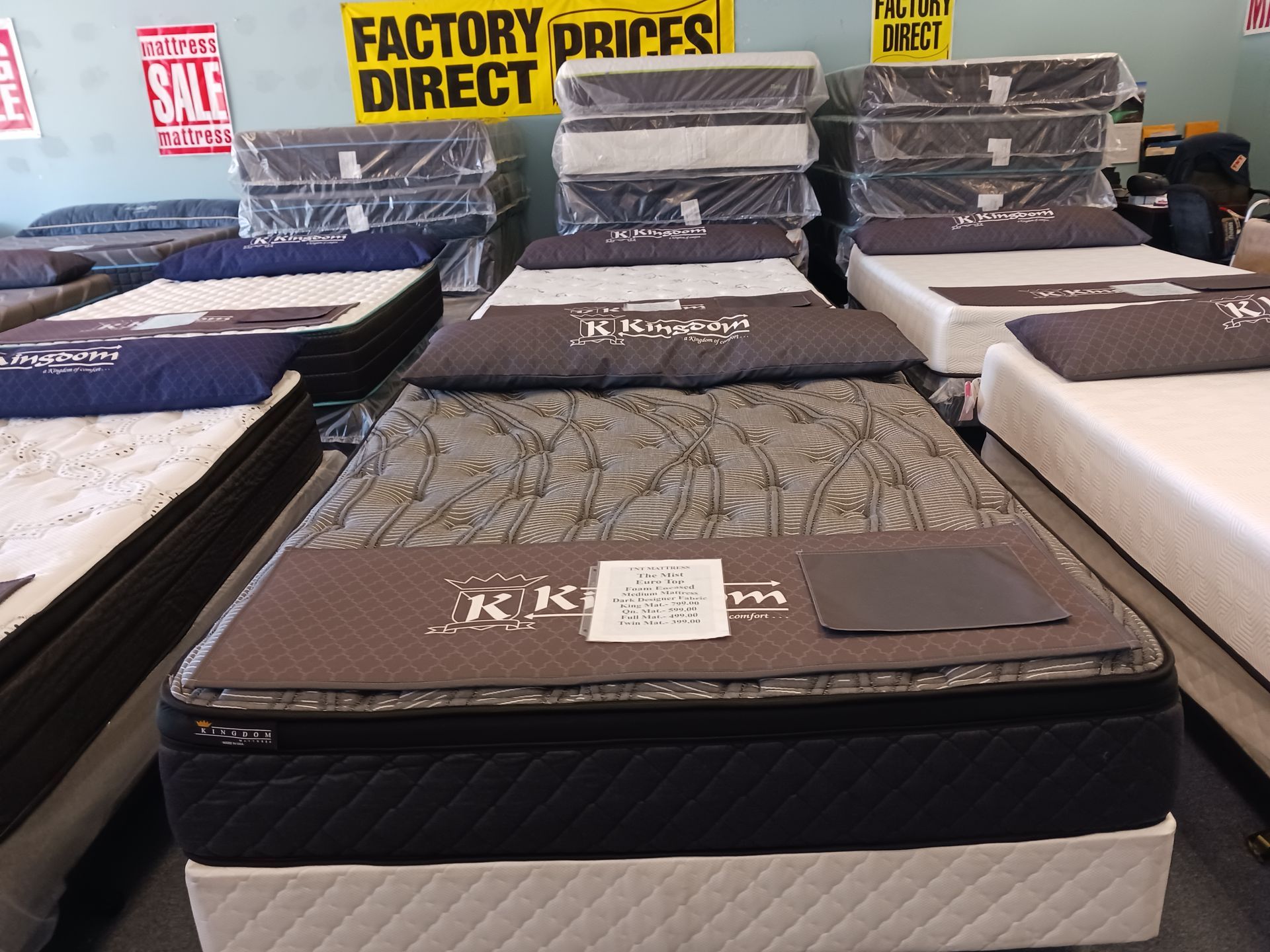 A mattress in a store with a sign that says factory prices direct