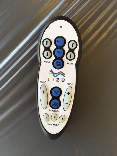 A white and black remote control with the word rize on it