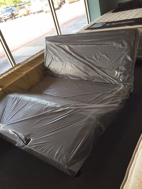 A couch is wrapped in plastic in a store
