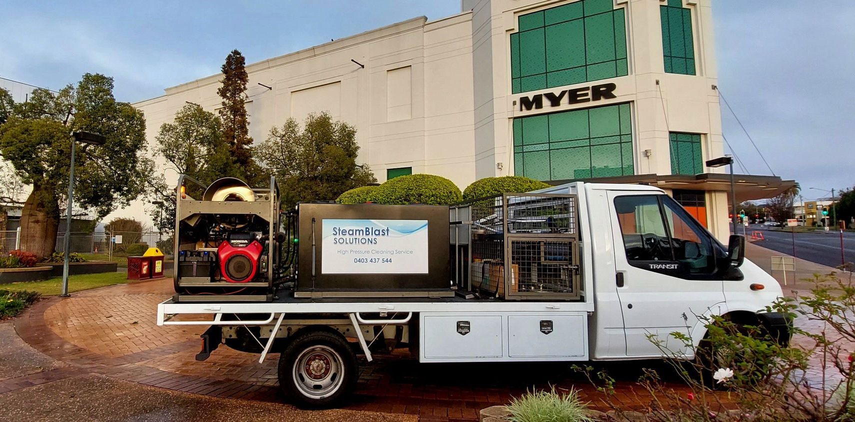 White utility truck in front of a building with