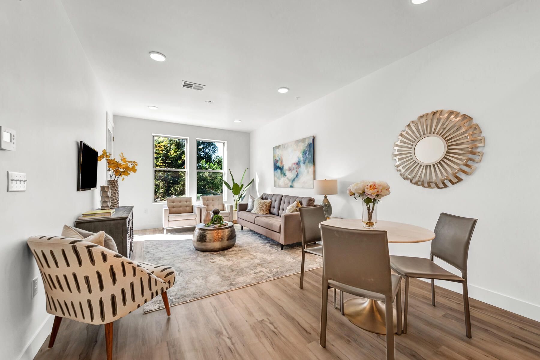 Living room with modern furniture, neutral colors, and a round dining table.