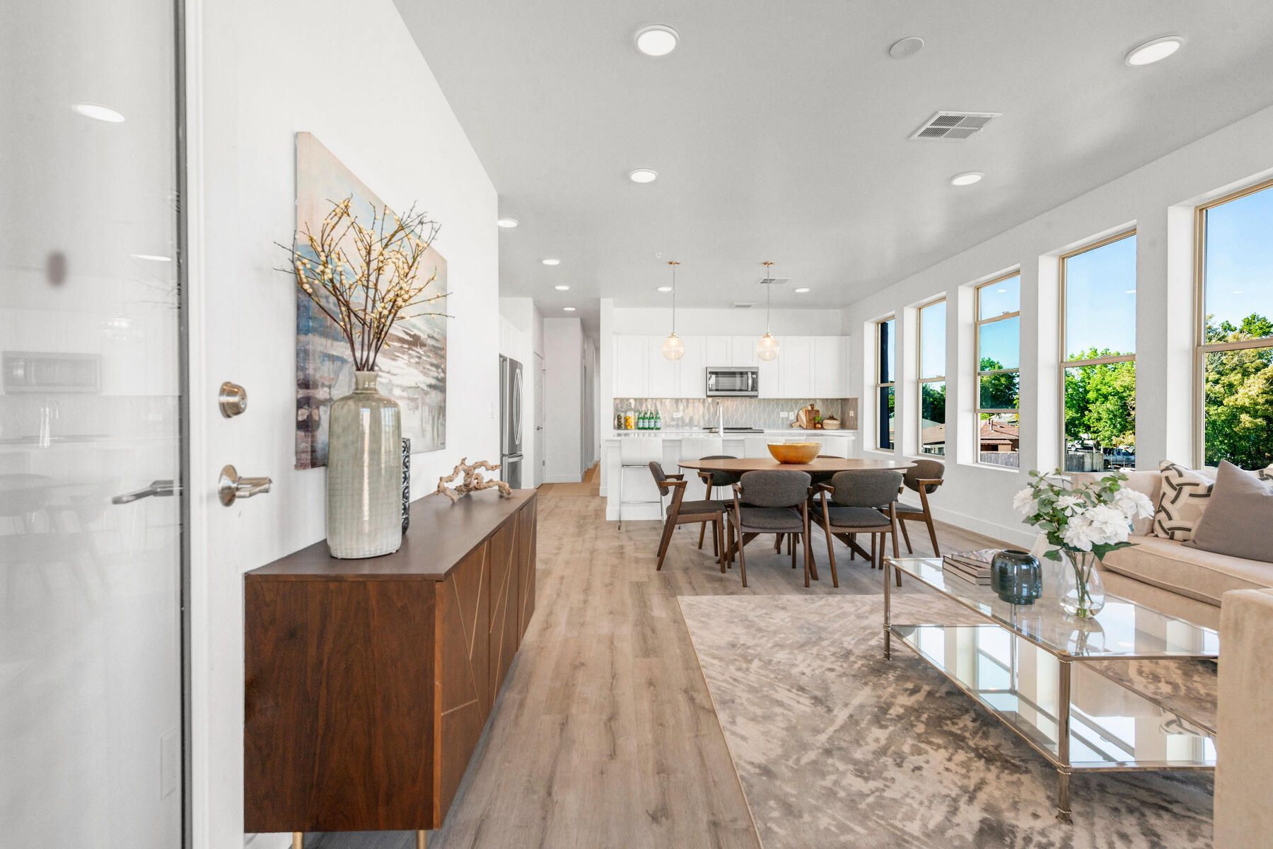 Modern home interior with dining area, kitchen, and living room.