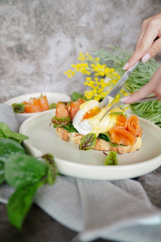 Person Cutting Open a Poached Egg — Cafe, Bar and Catering Services in Southport, QLD