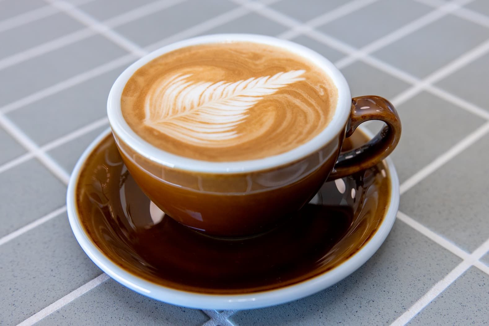 A Mug of Coffee With Latte Art on the Surface — Cafe, Bar and Catering Services in Southport, QLD