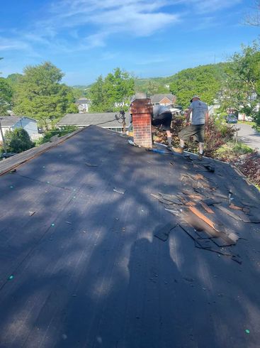 A man is working on the roof of a house.