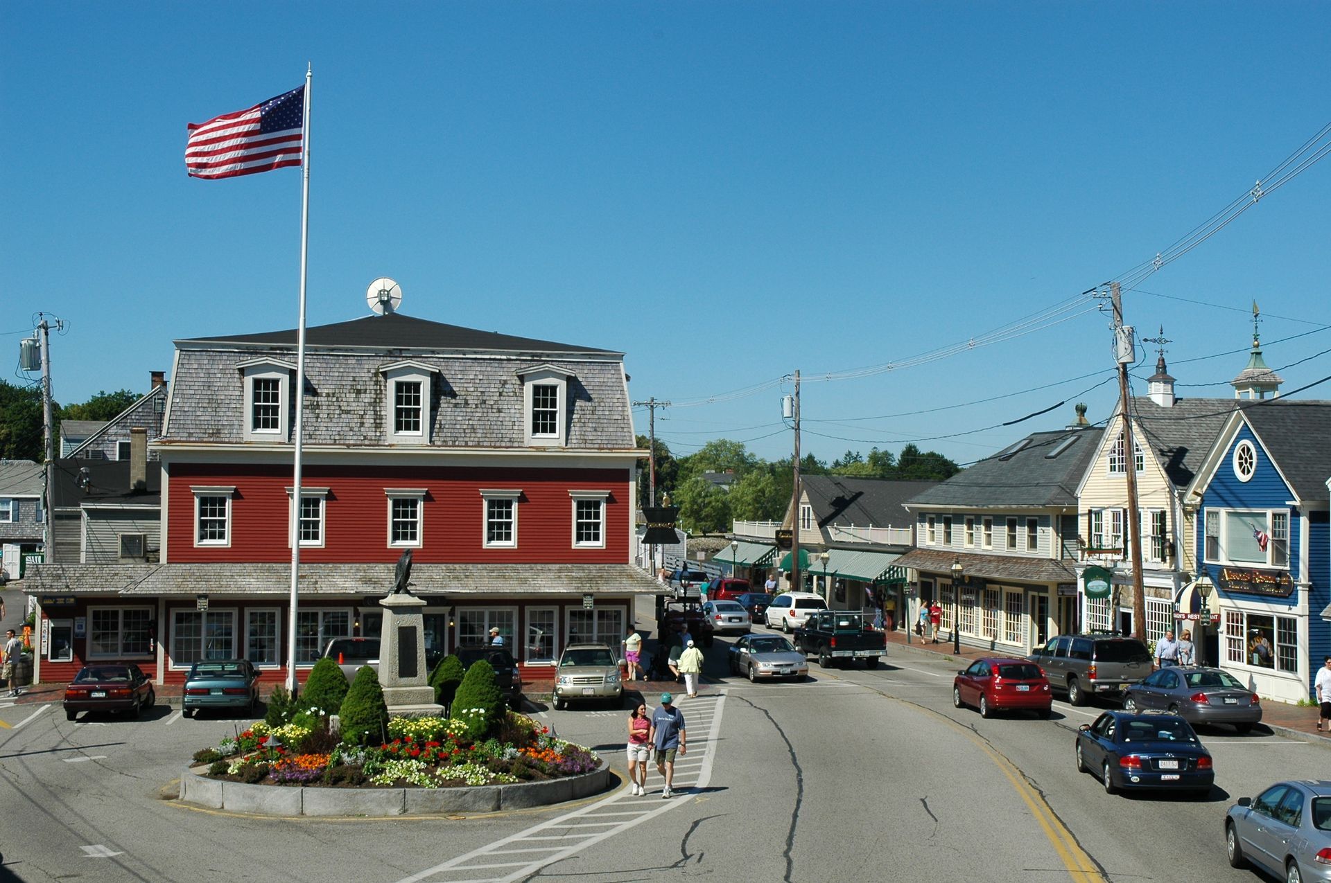 An american flag is flying in front of a red building