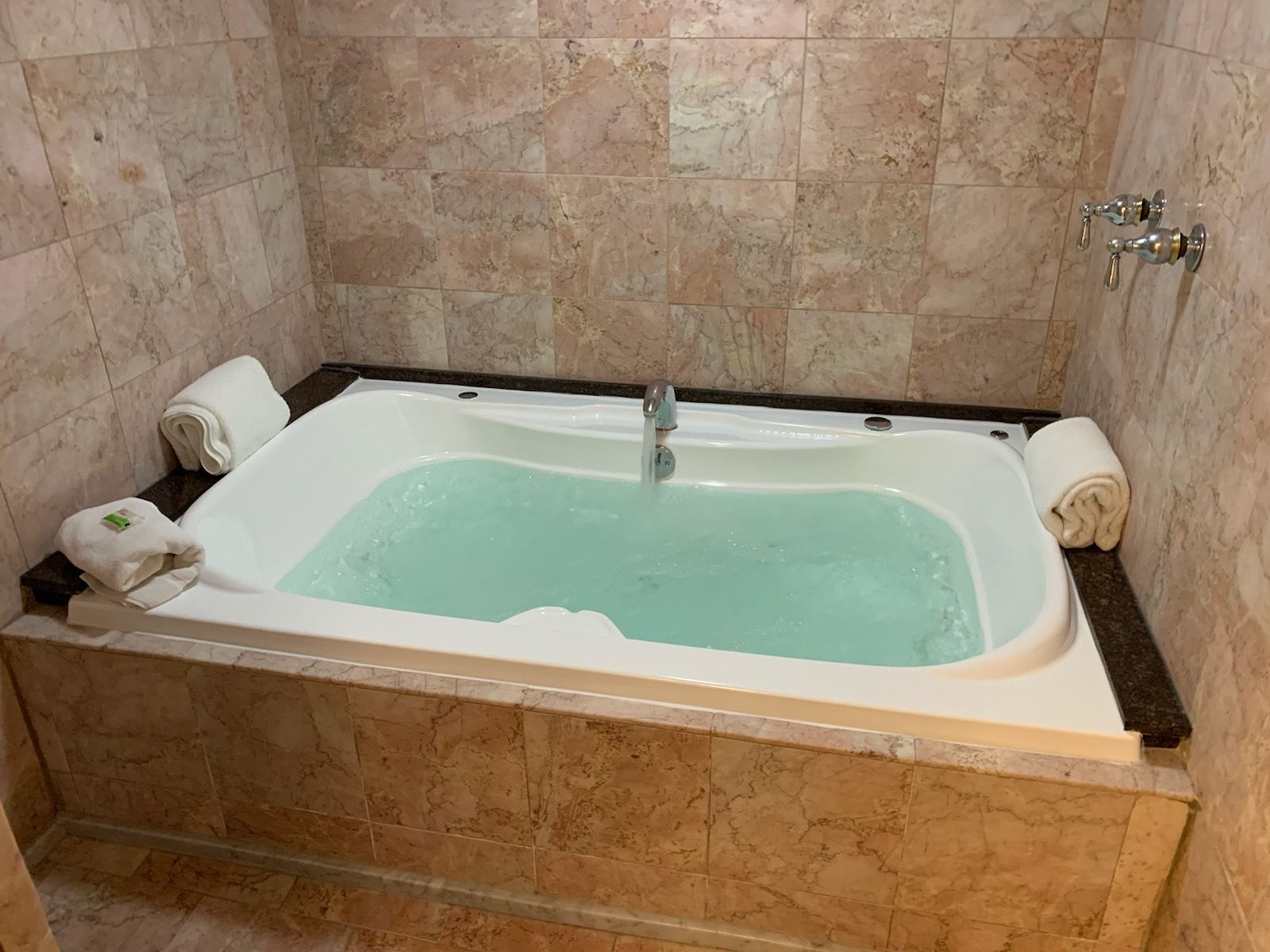 A large jacuzzi tub filled with water in a bathroom.