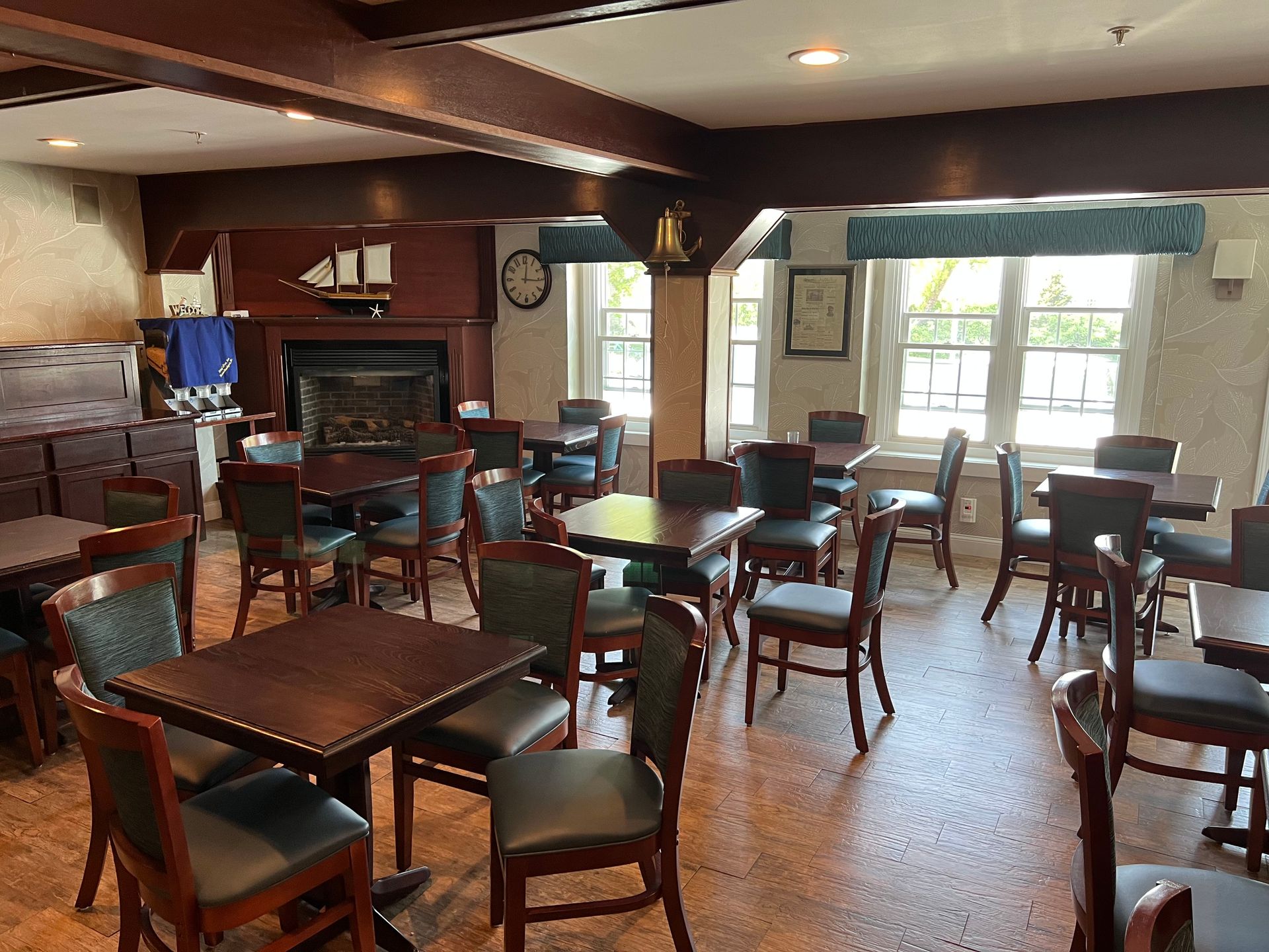 A restaurant with tables and chairs and a fireplace.