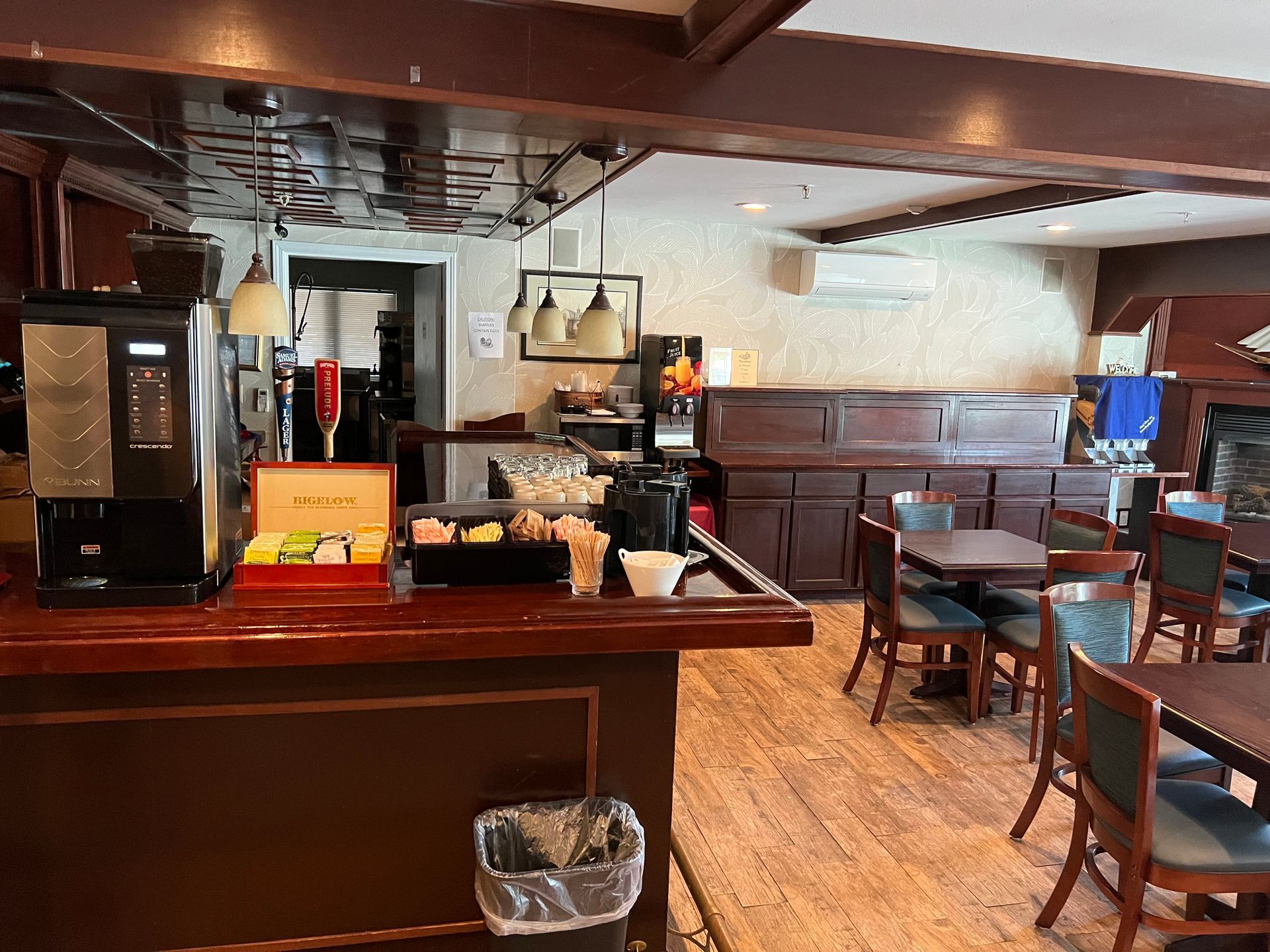 A restaurant with tables and chairs and a bar.