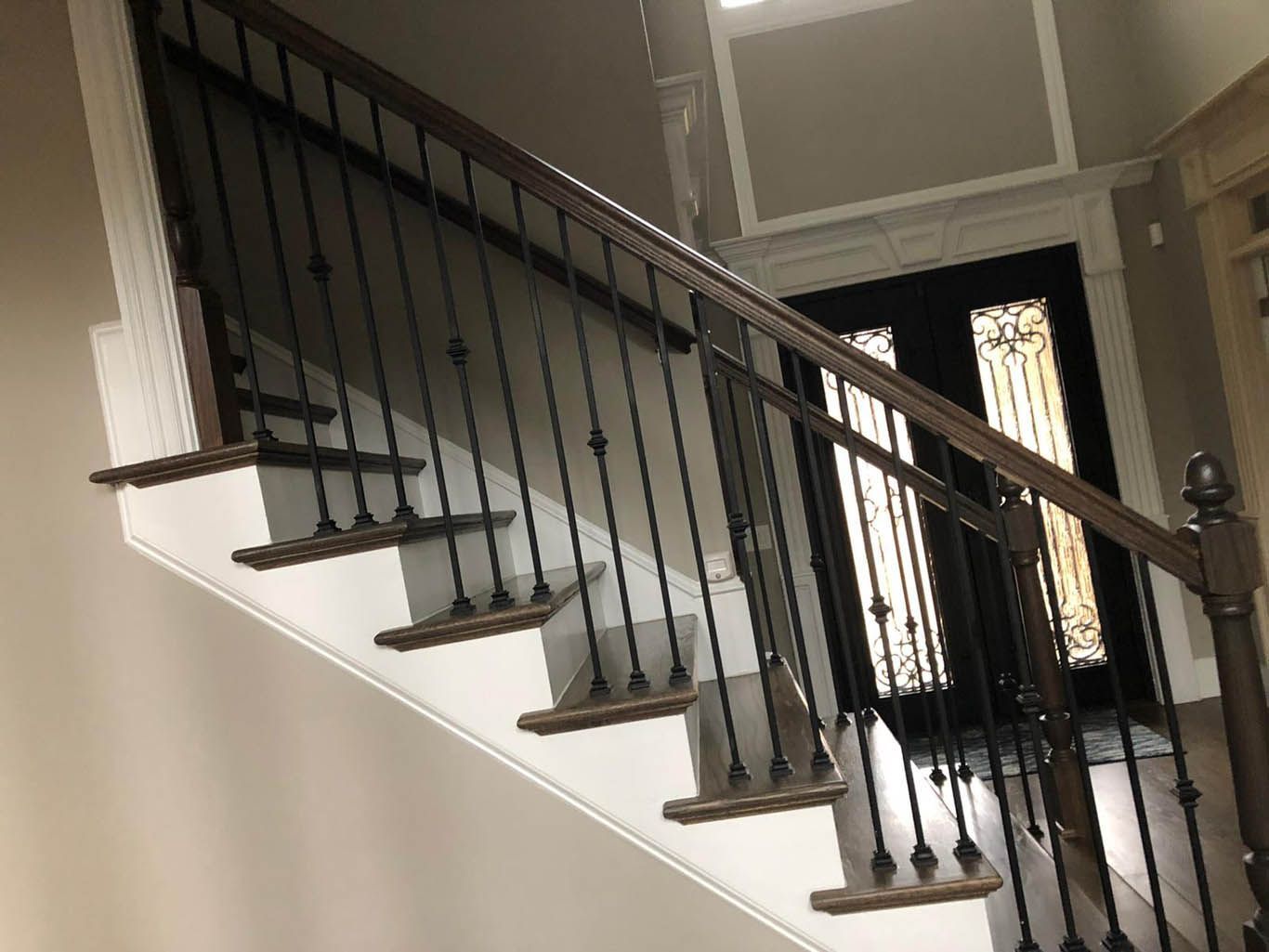 A staircase with a wrought iron railing and wooden steps in a house.