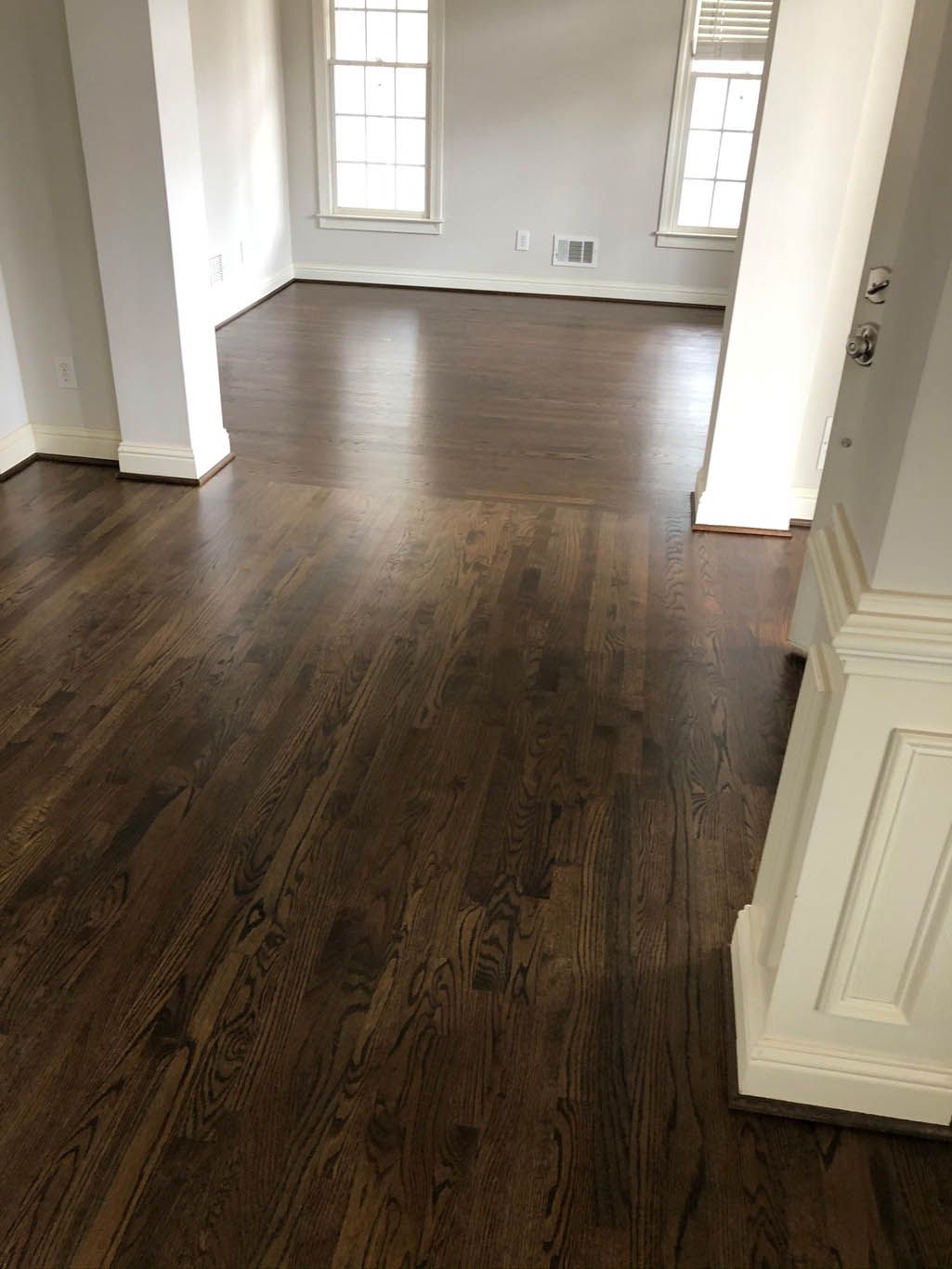 A living room with hardwood floors and white walls.
