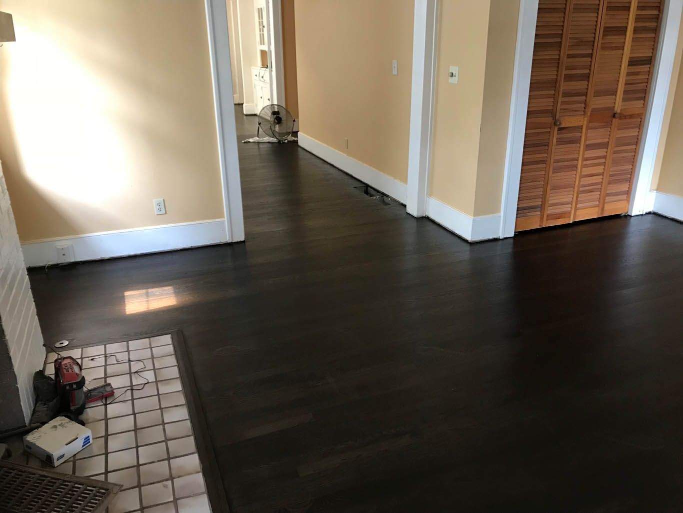 An empty room with hardwood floors and shuttered doors.