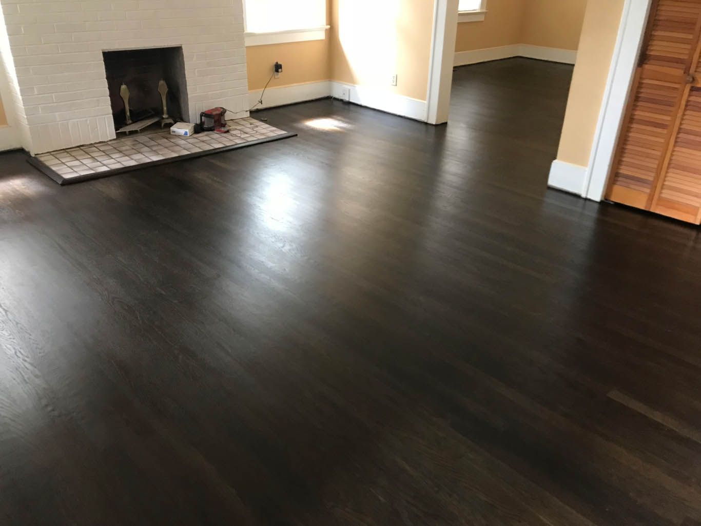 A living room with hardwood floors and a fireplace.