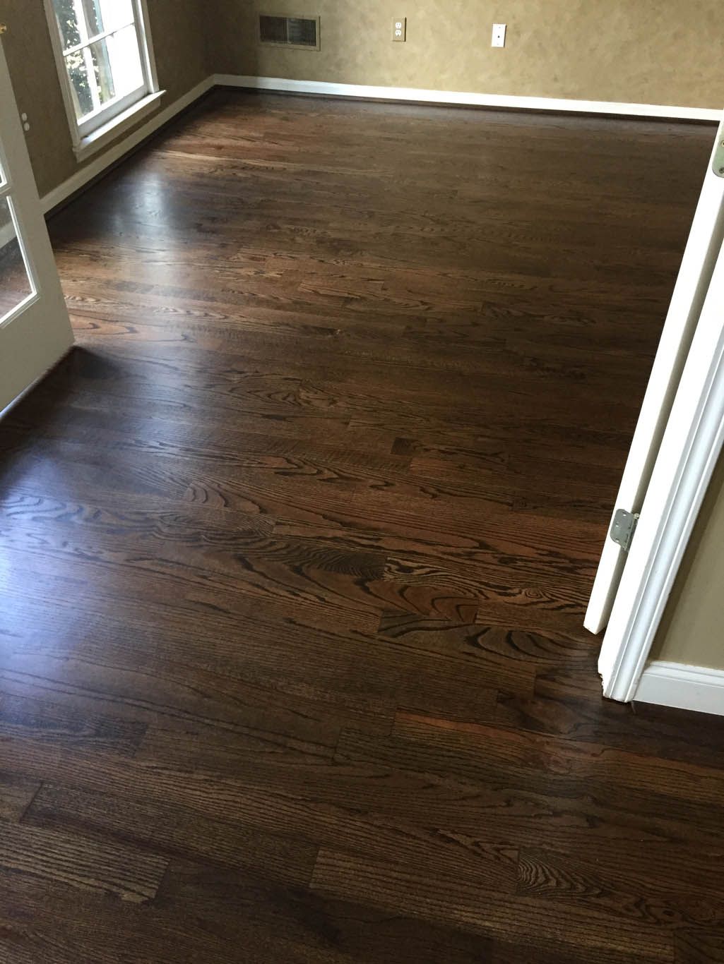 A living room with a wooden floor and a sliding glass door.