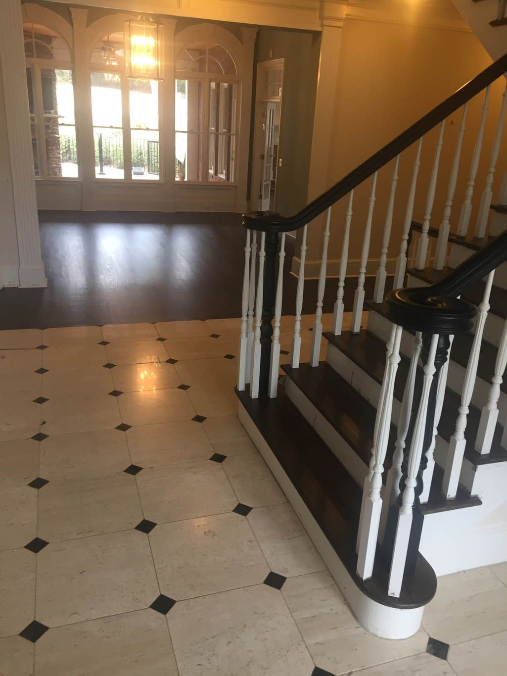 A staircase with a white railing and black steps in an empty room