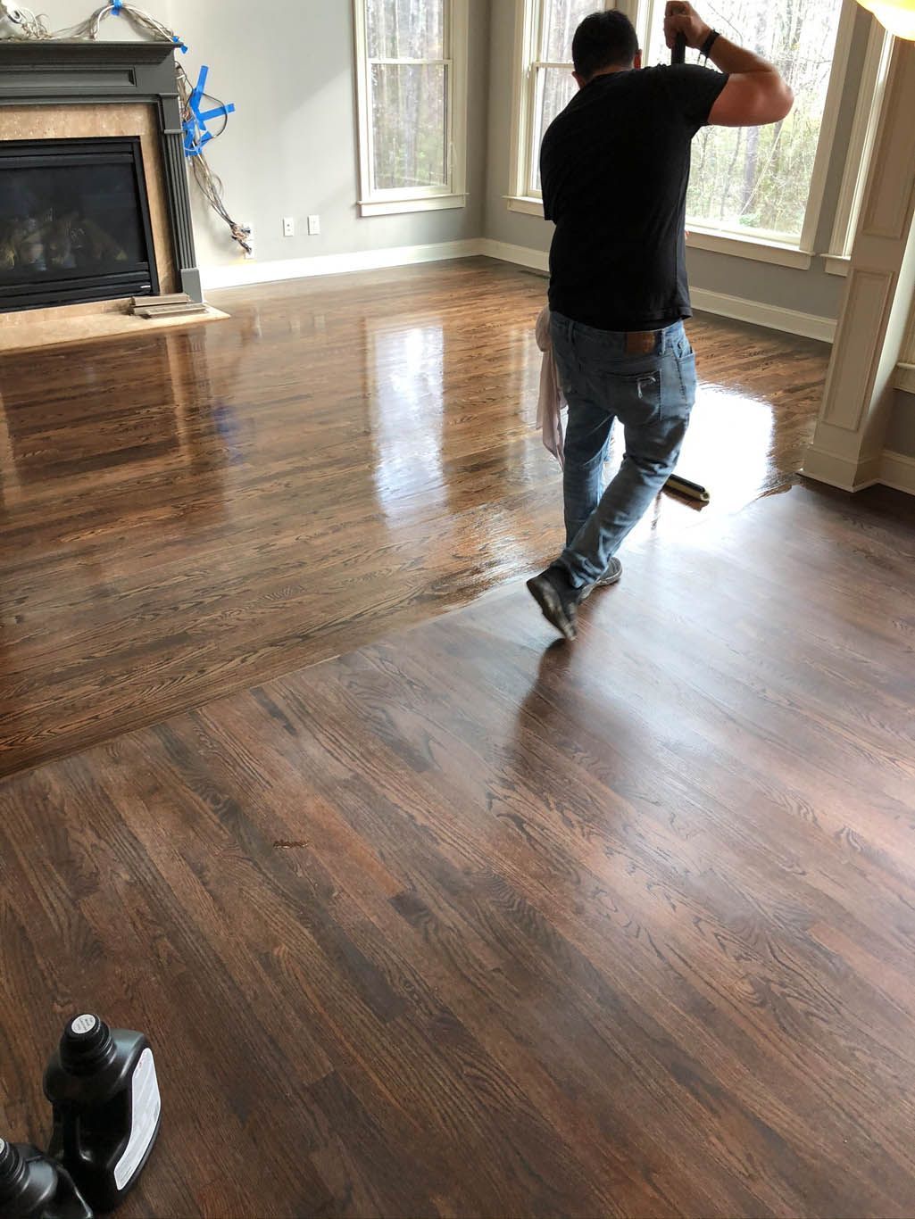 A man is walking on a wooden floor in a living room.