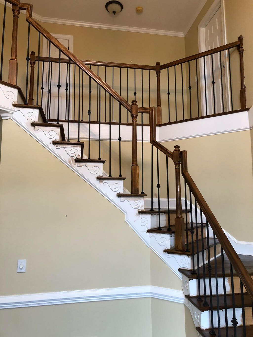 A wooden staircase with a metal railing in a house