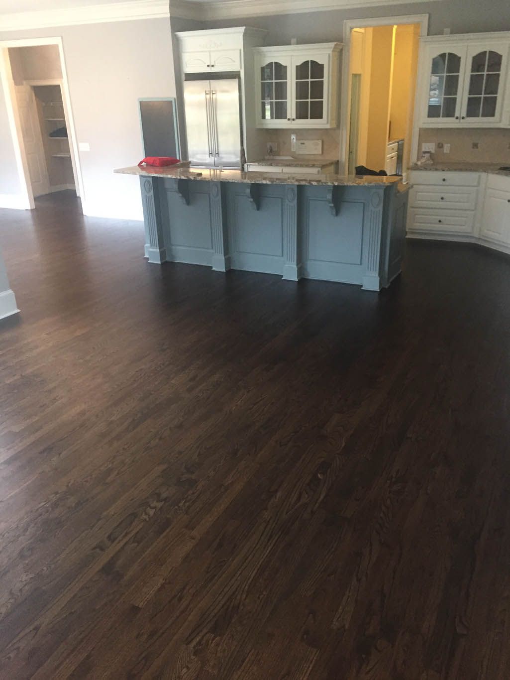 A kitchen with hardwood floors and a blue island.