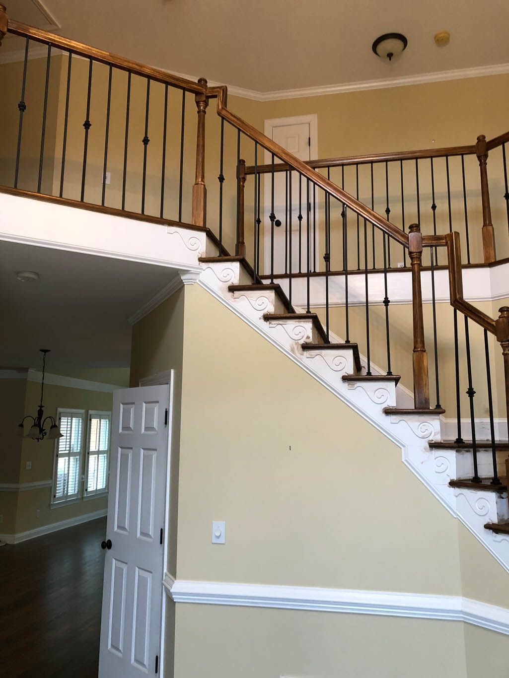 A staircase in a house with a wrought iron railing