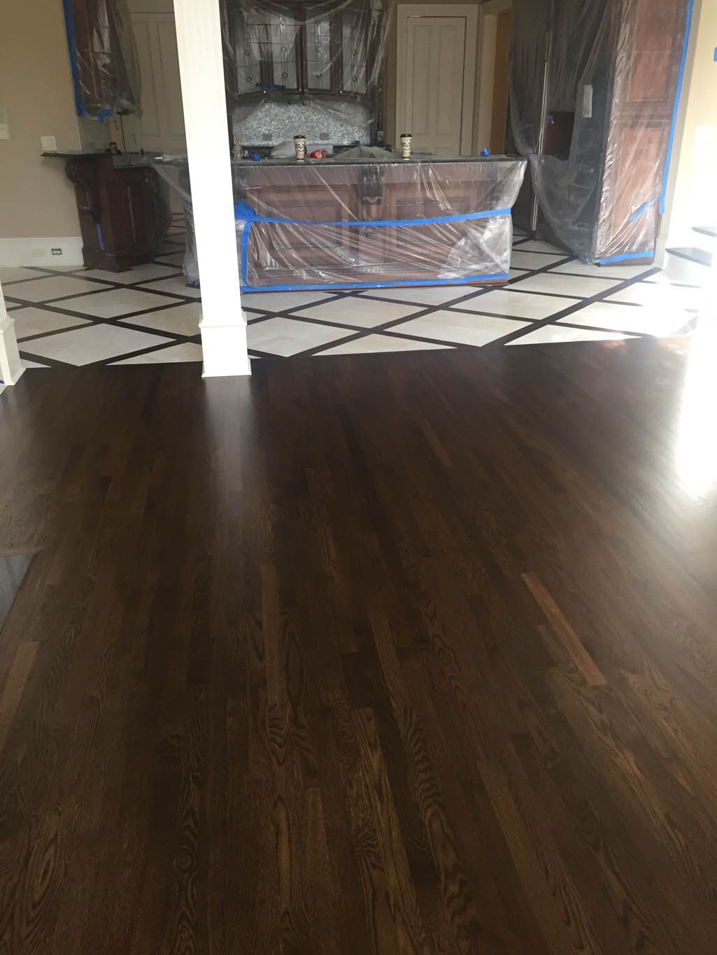 A wooden floor in a room with a checkered tile floor.