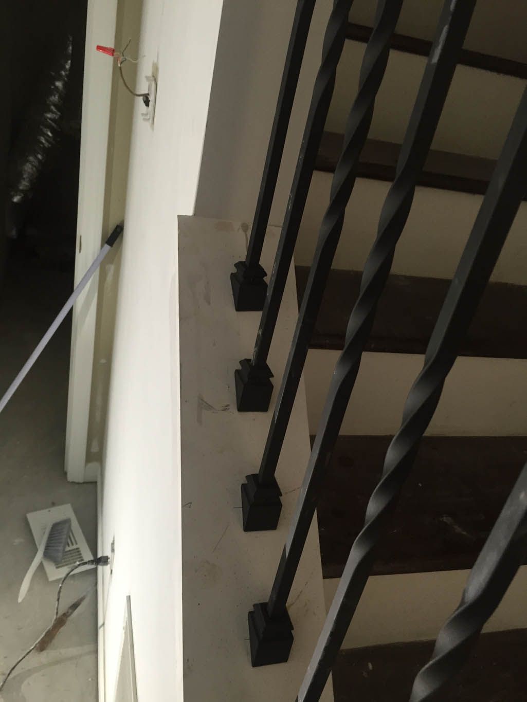 A staircase with a black railing and a white wall